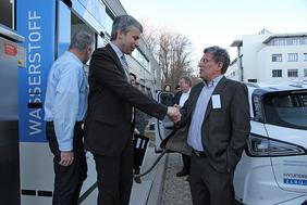 Prof. Werner Tillmetz, ehemaliges ZSW-Vorstandsmitglied, begrüßt Staatssekretär Bilger an der Brennstoffzellentankstelle am ZSW